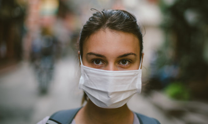 Young woman with face mask in the street